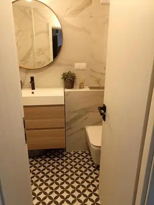 a bathroom with a sink and a toilet and a mirror at Modern Cozy Apartment in Kyustendil