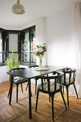 a dining room table with chairs and a vase of flowers at Modern Cozy Apartment in Kyustendil