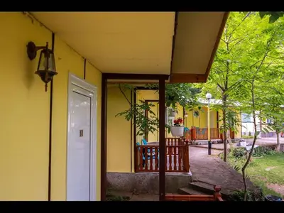 an outside view of a yellow house with a porch at Nice bungalow in Petrich in Kamena