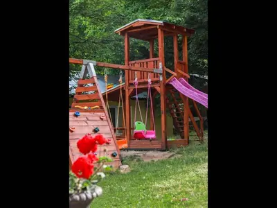 a wooden playground with a slide and a swing at Nice bungalow in Petrich in Kamena