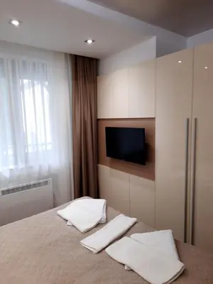a bedroom with a bed with two white towels at Луксозен апартамент - 