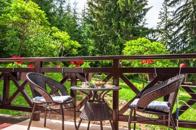 two chairs and a table on a balcony with flowers at Луксозен апартамент - 