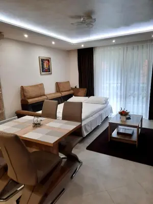 a hotel room with a bed and a table at Луксозен апартамент - 
