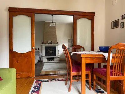 a dining room with a table and chairs and a fireplace at Willy Villy`s house in Chepelare