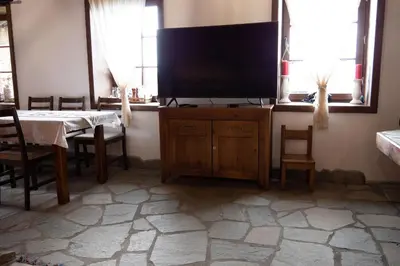 a tv on a cabinet in a room with a table at LITTLE BIRD Residency - Luxury Guesthouses in Leshten in Leshten