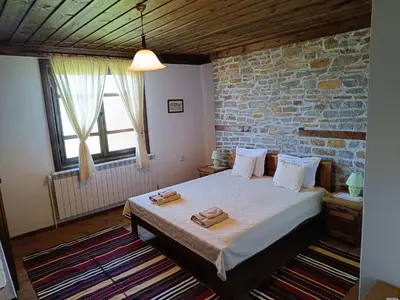 a bedroom with a bed and a brick wall at LITTLE BIRD Residency - Luxury Guesthouses in Leshten in Leshten