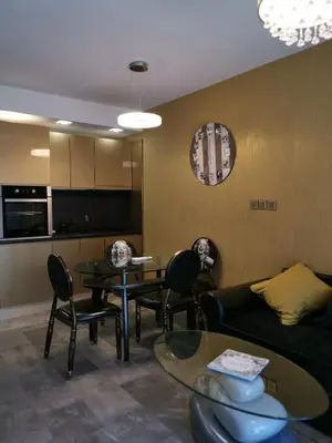 a living room with a couch and a table and chairs at Мирков Дар in Bansko