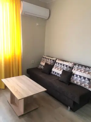 a living room with a couch and a table at Стаи за гости Праматарови Огняново in Ognyanovo