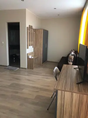 a living room with a couch and a table with a television at Стаи за гости Праматарови Огняново in Ognyanovo