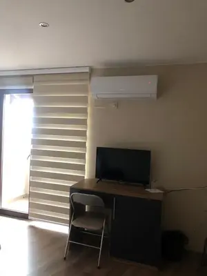 a desk with a monitor and a chair next to a window at Стаи за гости Праматарови Огняново in Ognyanovo