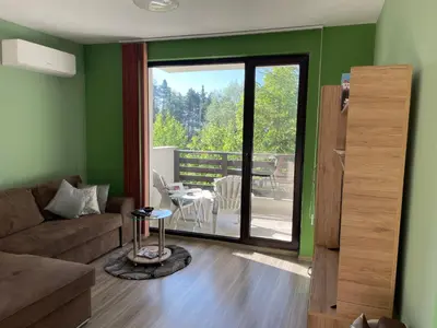 a living room with a couch and a sliding glass door at Nikol Deluxe in Velingrad