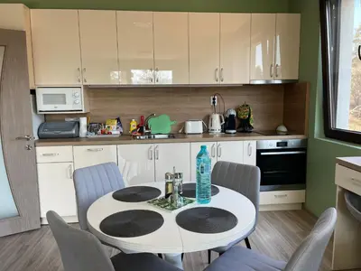 a kitchen with a table and chairs in a kitchen at Nikol Deluxe in Velingrad
