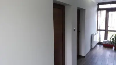 a hallway with a wooden door and a window at Sharkov Guest House in Dolen