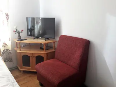 a red chair sitting next to a tv in a room at Sharkov Guest House in Dolen