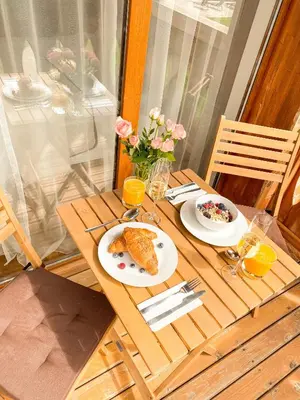 a wooden table with two plates of food on it at Pirin Golf Studio Apartment in Razlog