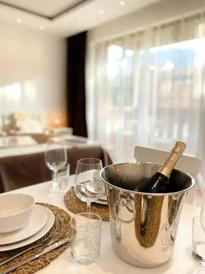 a bottle of wine in a bucket on a table at Pirin Golf Studio Apartment in Razlog