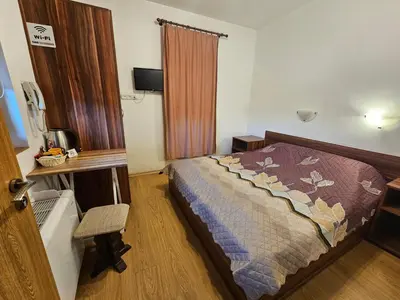 a hotel room with a bed and a window at Емили Фемили Хаус in Koprivshtitsa
