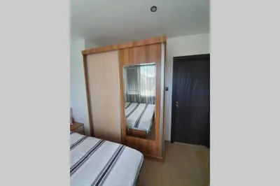a bedroom with a mirror next to a bed at Луксозен апартамент с WiFi на 10км от Боровец in Samokov