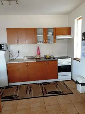 a kitchen with wooden cabinets and a white stove at Вили Green in Tsigov Chark