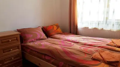 a bed in a bedroom with a dresser and a window at Вили Green in Tsigov Chark