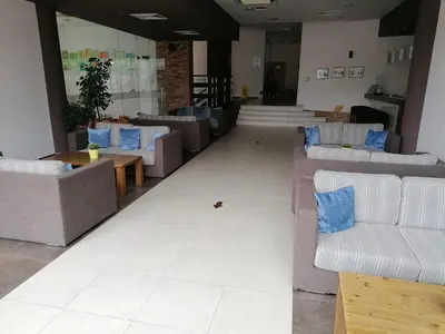 a lobby with couches and tables and blue pillows at Aspen Golf - private apartments in Razlog