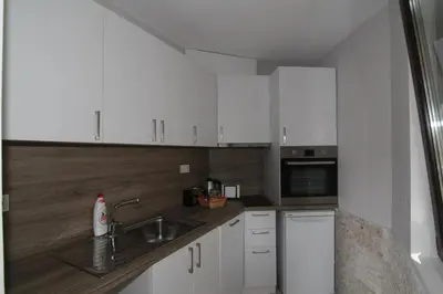 a kitchen with white cabinets and a sink at Bendida Apartments in Velingrad