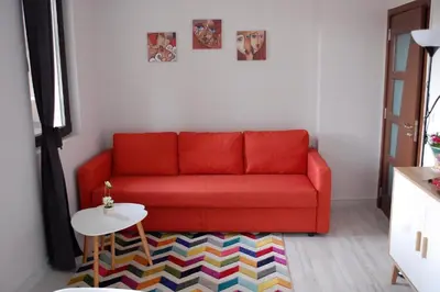 a red couch in a living room with a table at Bendida Apartments in Velingrad