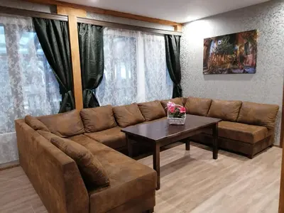 a living room with a brown couch and a table at Къща за гости ЕКО in Tsigov Chark