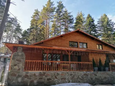 a log cabin in the woods with a balcony at Къща за гости ЕКО in Tsigov Chark