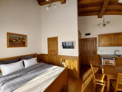 a bedroom with a bed and a table and a kitchen at Airy Studio Pirin Golf Aparthotel SPA H2A92 in Razlog