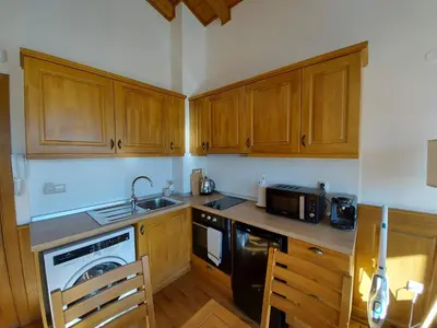 a kitchen with wooden cabinets and a sink and a stove at Airy Studio Pirin Golf Aparthotel SPA H2A92 in Razlog