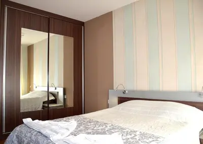 a bedroom with a bed and a mirror at Къщи за гости 