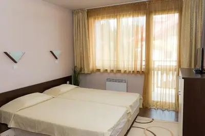 a bedroom with two beds in front of a window at Апартамент DIMANI-Апартхотел Форест Нук Пампорово in Pamporovo