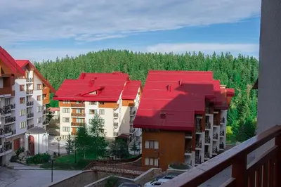 a group of apartment buildings with red roofs at Апартамент DIMANI-Апартхотел Форест Нук Пампорово in Pamporovo