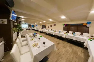 a banquet hall with white tables and white chairs at Апартамент DIMANI-Апартхотел Форест Нук Пампорово in Pamporovo