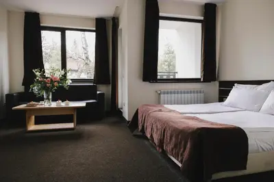 a hotel room with a bed and a table with flowers on it at Borovets Green Hotel in Borovets