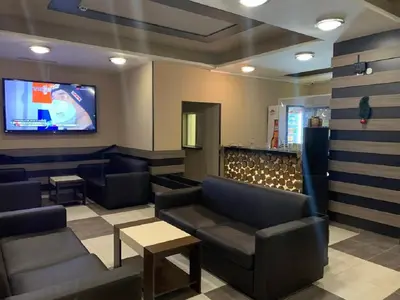 a waiting room with couches and a flat screen tv at Borovets Green Hotel in Borovets