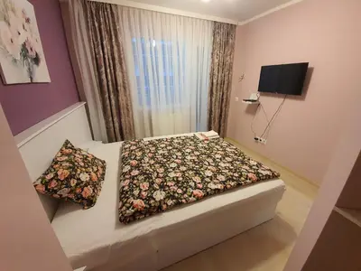 a small bedroom with a bed with a flower blanket at GUEST SUITE Narodno horo in Sofia