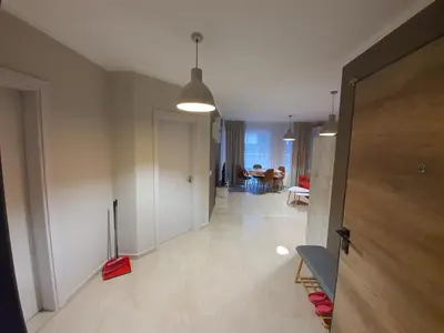 a room with a hallway with a door and a living room at GUEST SUITE Narodno horo in Sofia
