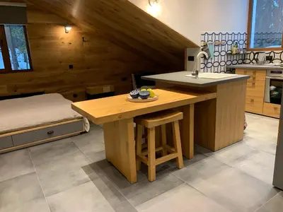 a kitchen with a wooden table and a sink at Golden Box Pamporovo in Pamporovo