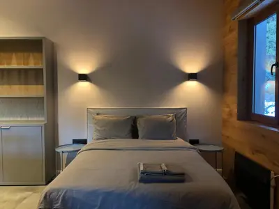 a bedroom with a large bed with two tables at Golden Box Pamporovo in Pamporovo
