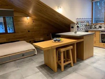 a kitchen with a table and a bed in a room at Golden Box Pamporovo in Pamporovo