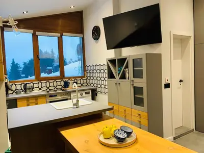 a kitchen with a sink and a counter with a table at Golden Box Pamporovo in Pamporovo