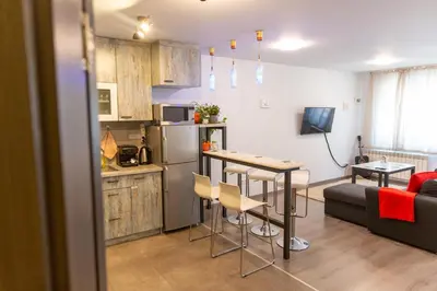 a kitchen and living room with a table and a couch at Fancy Big apartment in the heart of Sofia in Sofia