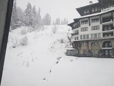 a snow covered yard in front of a building at Snow Dreams 1 Grand Monastery in Pamporovo