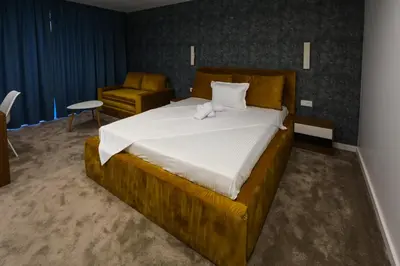 a bedroom with a large bed and a chair at GRAFFIT Luxury houses in Ognyanovo