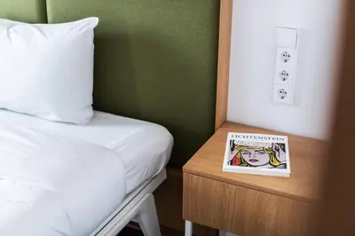 a book sitting on a night stand next to a bed at Hotel Kitchen59 in Sofia