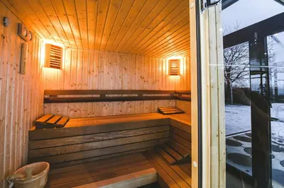 a sauna with a bench in a wooden building at Hotel Villa Ekaterina in Vakarel