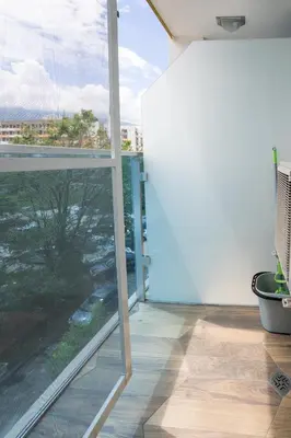 a balcony with a large window with a view of a city at Cozy little apartment in Studentski grad in Sofia