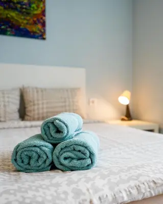 a pile of towels sitting on top of a bed at Cozy little apartment in Studentski grad in Sofia